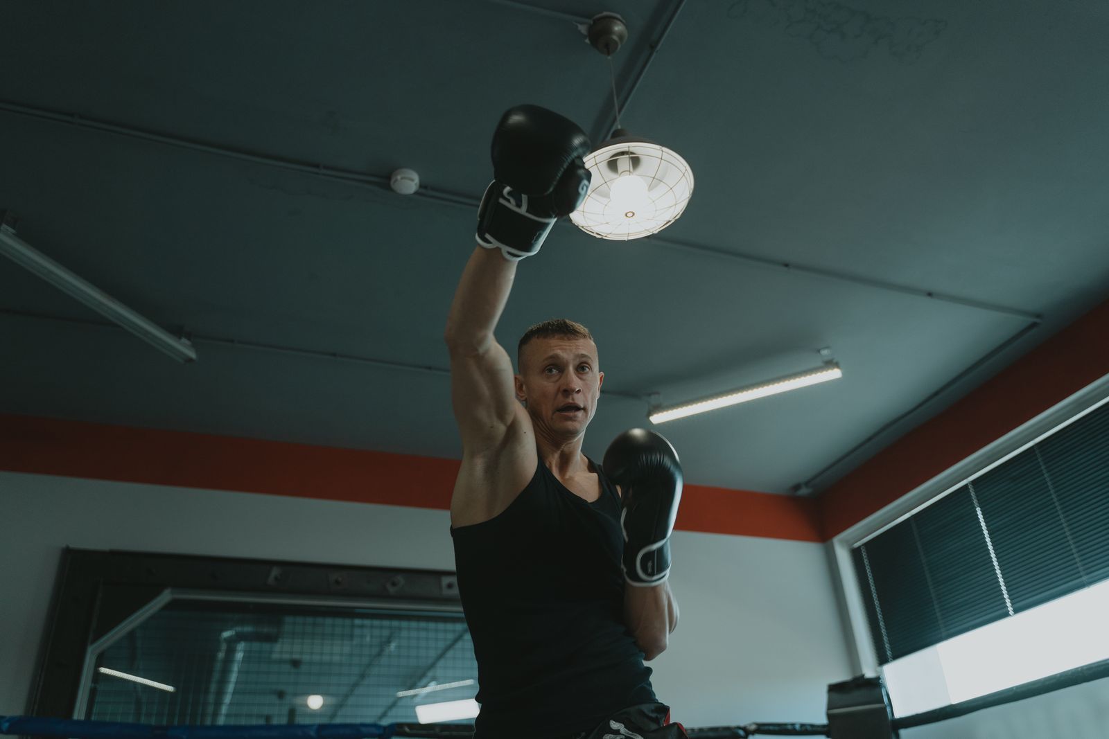 Boxer training with his guard up and a glove extended in a boxing gym