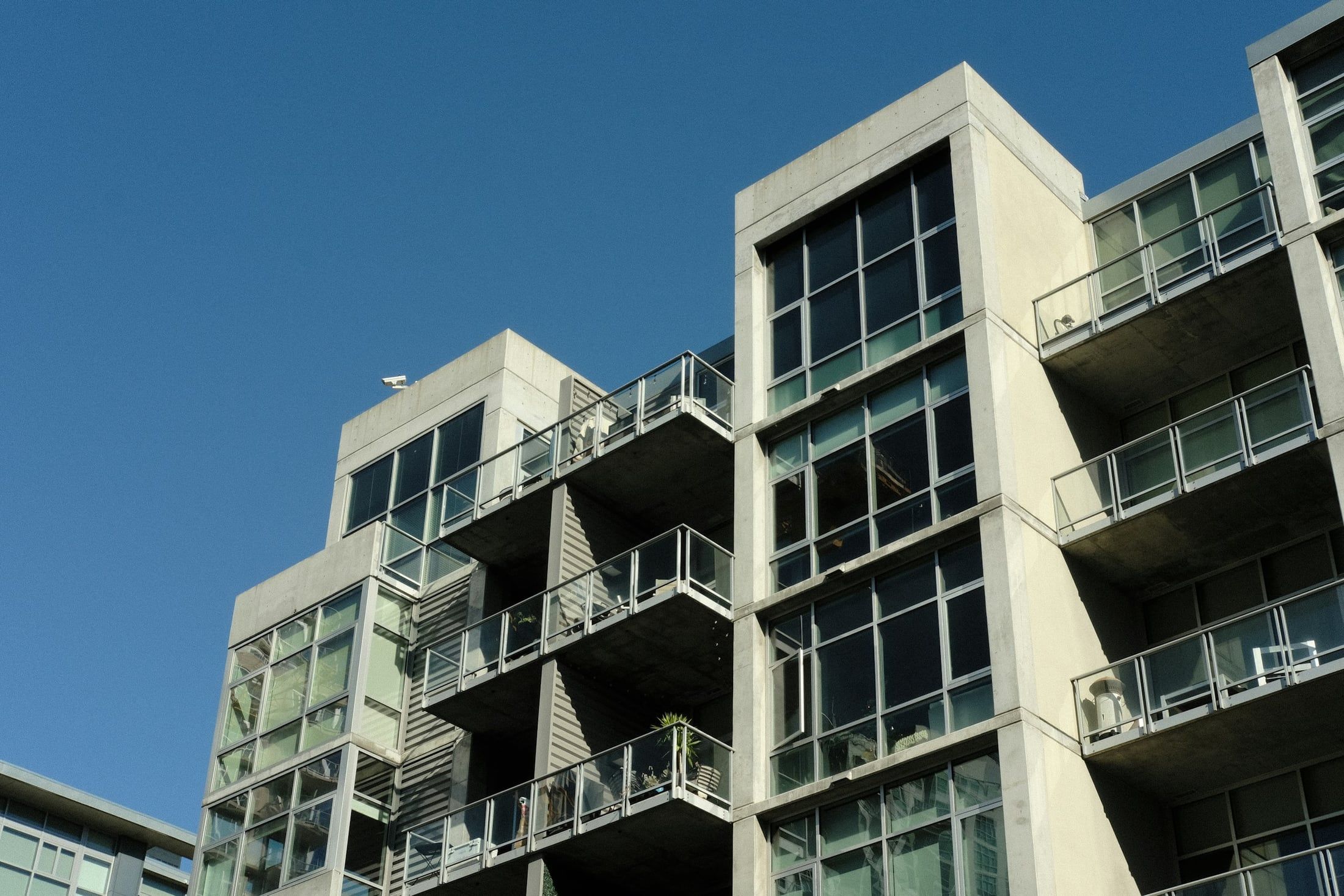 Contemporary concrete apartment buildings with long glass balconies and an open sky